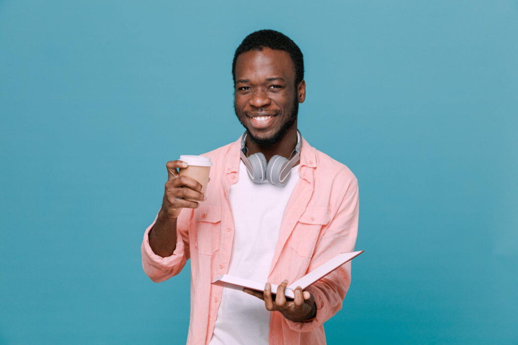 Ragazzo con libro che beve un caffè